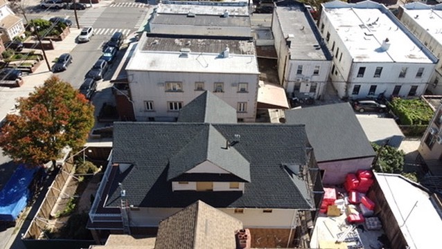 Completed shingle roof surrounded by neighbouring Brooklyn rooftops seen from above