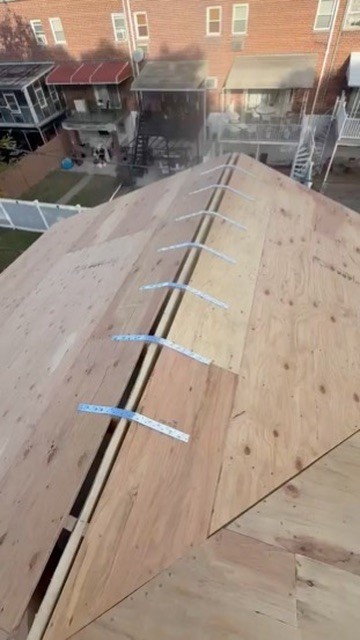 New plywood roof deck with a continuous ridge vent opening cut along the peak