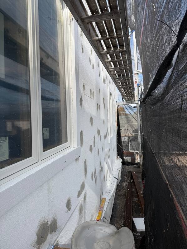 Workers finishing stucco on scaffold