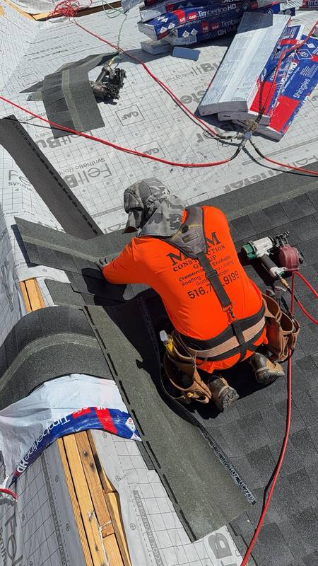 Worker installing GAF shingles nail gun Brooklyn