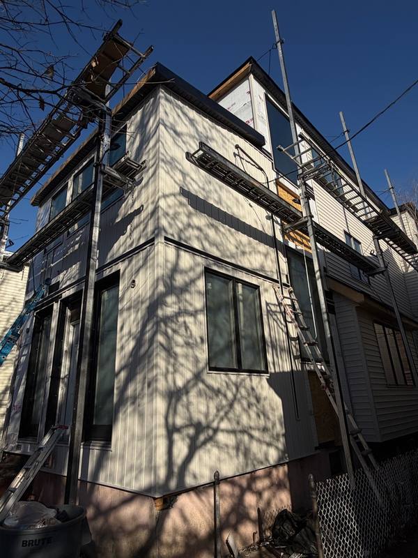MLM crew installing vertical siding panels Brooklyn home
